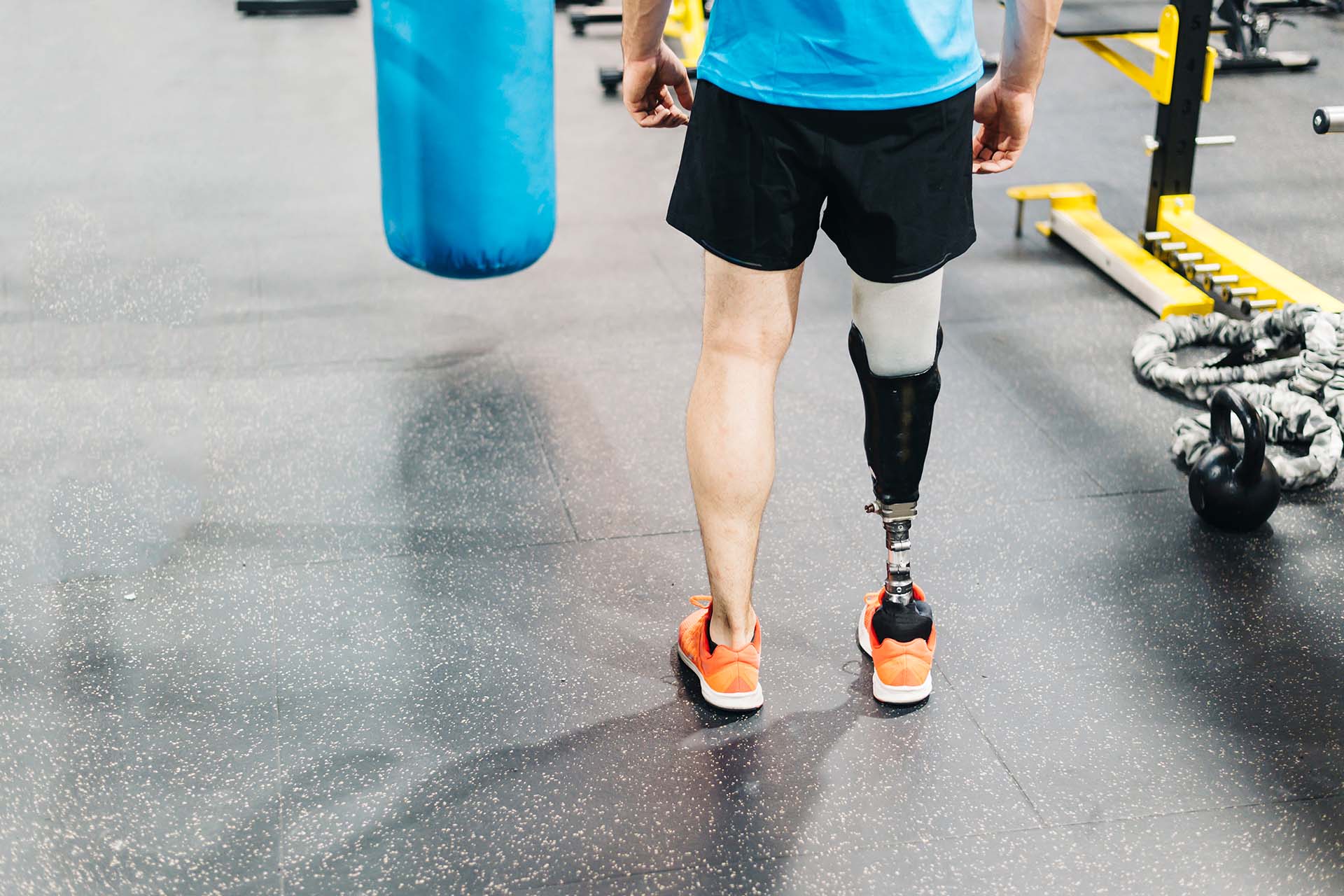 Athlete with leg prosthesis training at the gym